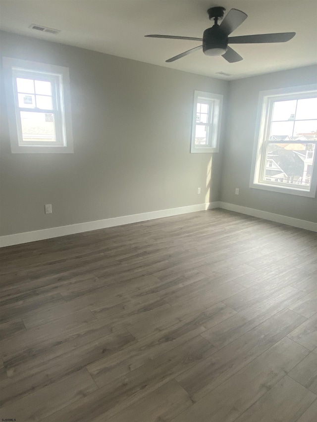 unfurnished room with ceiling fan and dark hardwood / wood-style flooring