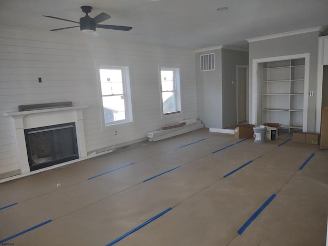 unfurnished living room featuring ceiling fan and ornamental molding