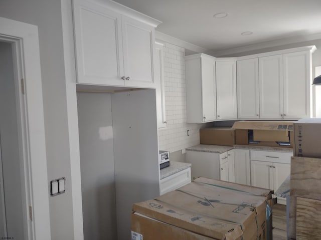 kitchen with decorative backsplash and white cabinets