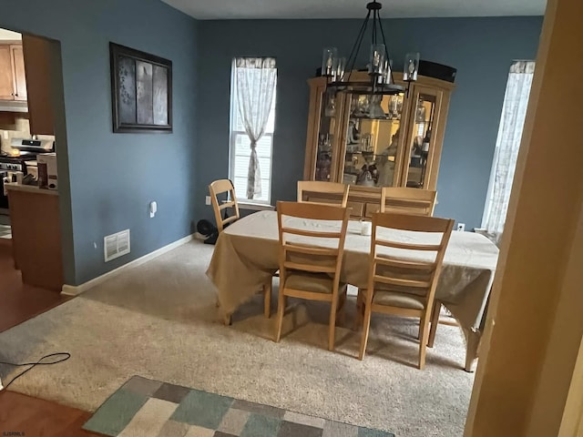 dining space with an inviting chandelier and carpet floors