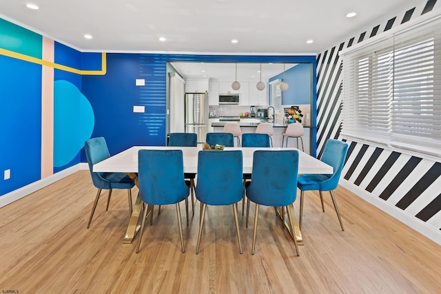 dining space featuring sink and light wood-type flooring