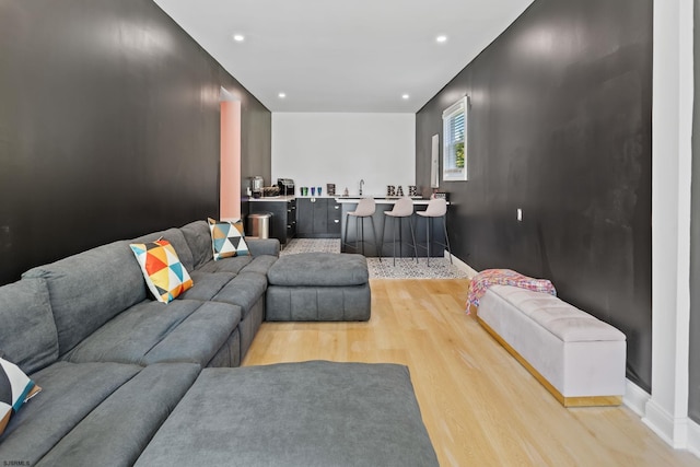 living room featuring sink and light hardwood / wood-style flooring