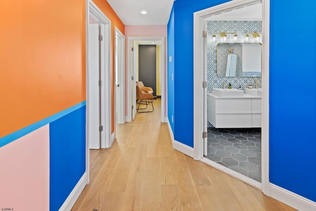 corridor with sink and light hardwood / wood-style flooring