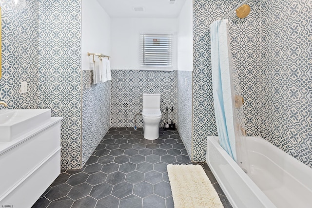 full bathroom featuring sink, tile walls, toilet, shower / bathtub combination with curtain, and tile patterned floors