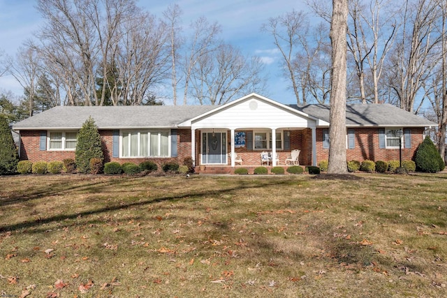 ranch-style home with a front yard and covered porch