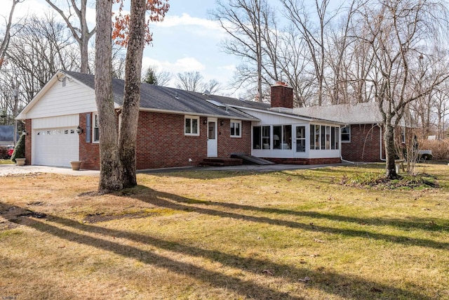 exterior space featuring a garage, a sunroom, and a front yard