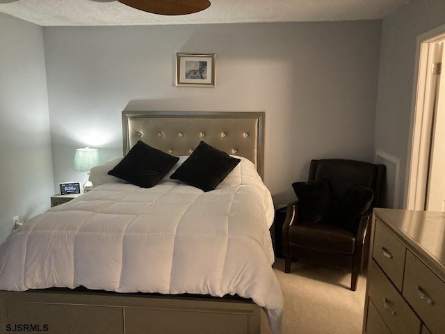 bedroom with light colored carpet and a textured ceiling