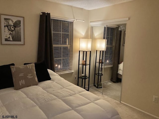 bedroom with light carpet and a textured ceiling