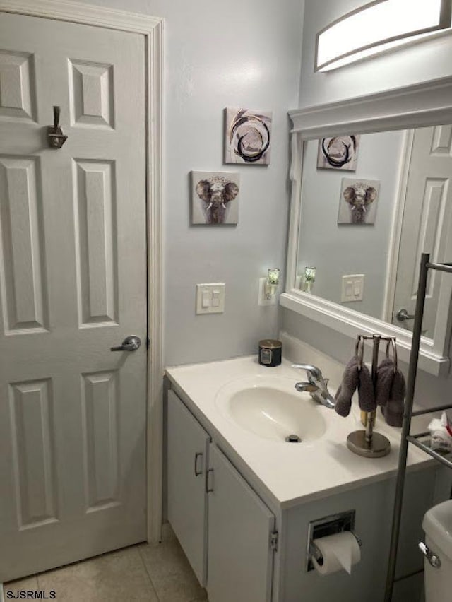 bathroom with vanity, tile patterned flooring, and toilet