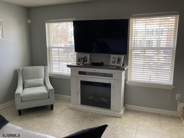 tiled living room with a premium fireplace, a textured ceiling, and a wealth of natural light