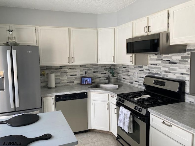 kitchen featuring white cabinetry, appliances with stainless steel finishes, sink, and tasteful backsplash