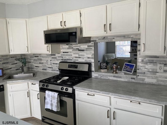 kitchen featuring white cabinetry, sink, decorative backsplash, and stainless steel appliances