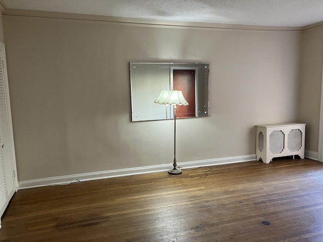 unfurnished room featuring crown molding and dark hardwood / wood-style floors