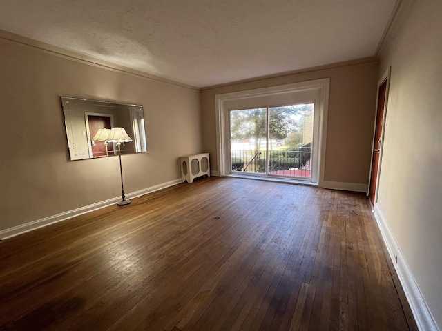 spare room featuring hardwood / wood-style flooring, ornamental molding, heating unit, and a textured ceiling