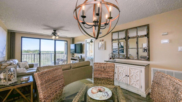 living room with ceiling fan with notable chandelier and a textured ceiling