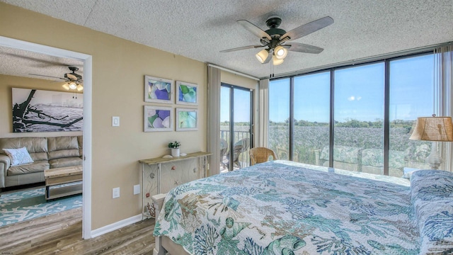 bedroom with ceiling fan, wood-type flooring, a textured ceiling, and a wall of windows