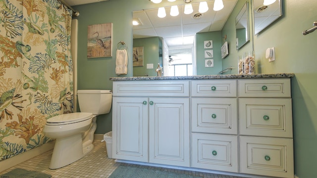 bathroom with tile patterned flooring, vanity, a paneled ceiling, and toilet