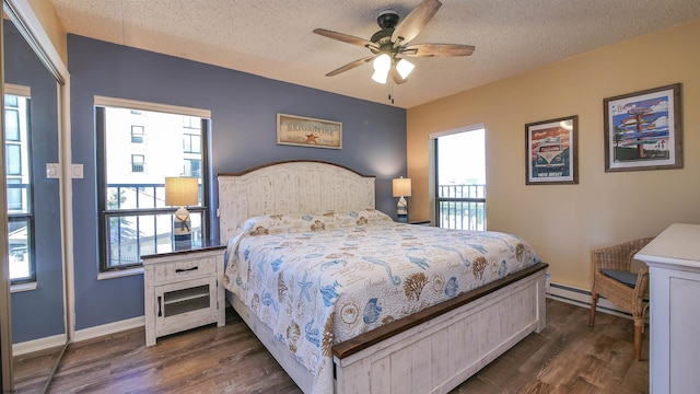 bedroom featuring multiple windows, a textured ceiling, and dark hardwood / wood-style flooring