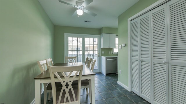 dining area featuring ceiling fan and dark tile patterned flooring