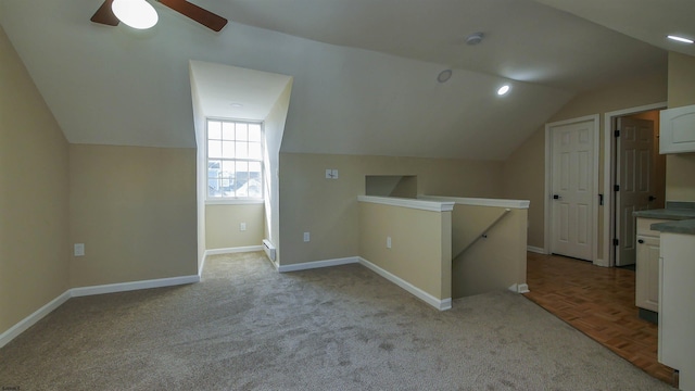 additional living space with ceiling fan, a baseboard radiator, vaulted ceiling, and light parquet floors