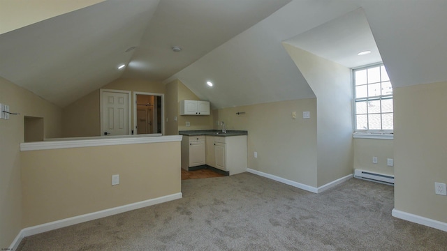 interior space with light colored carpet, sink, vaulted ceiling, and a baseboard heating unit