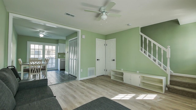 unfurnished living room featuring ceiling fan and light wood-type flooring