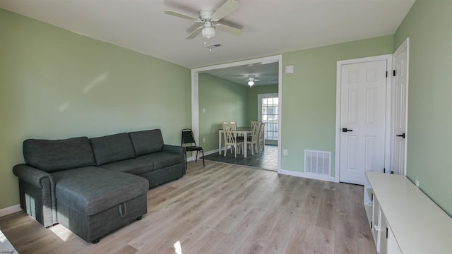 living room featuring light hardwood / wood-style flooring and ceiling fan