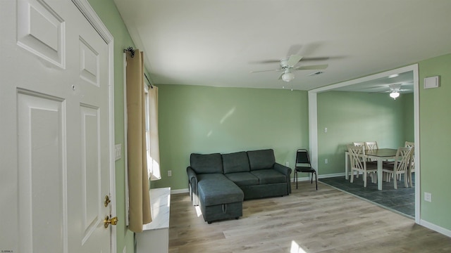 living room featuring ceiling fan and light hardwood / wood-style flooring