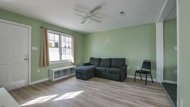 living room featuring ceiling fan and light wood-type flooring