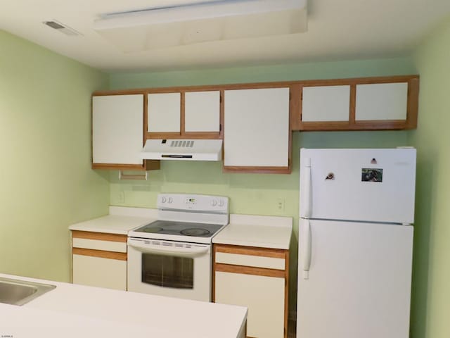 kitchen with sink, white appliances, and white cabinets