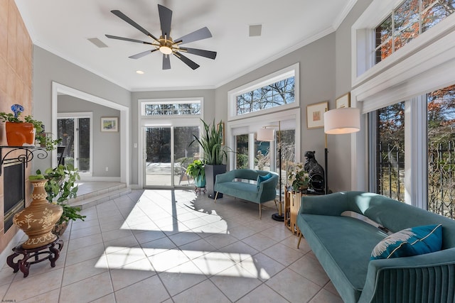 living room with crown molding, ceiling fan, a high ceiling, and light tile patterned floors