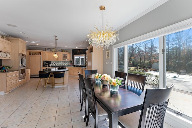 tiled dining area featuring an inviting chandelier, ornamental molding, and sink