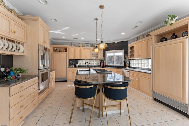 kitchen featuring light brown cabinetry, a kitchen bar, and a center island with sink