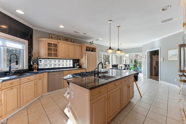 kitchen with light tile patterned flooring, stainless steel appliances, sink, and a center island with sink