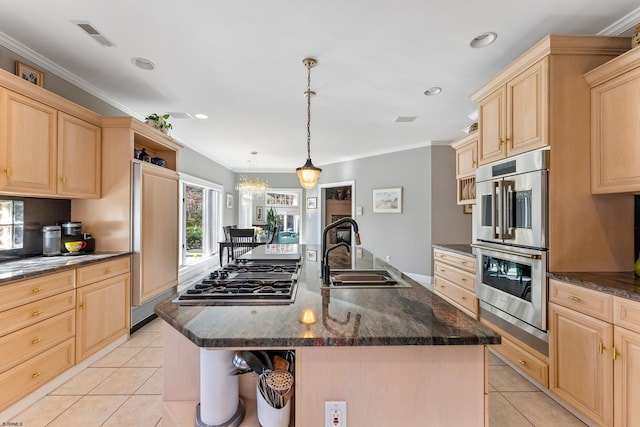 kitchen with hanging light fixtures, stainless steel appliances, sink, and a center island with sink