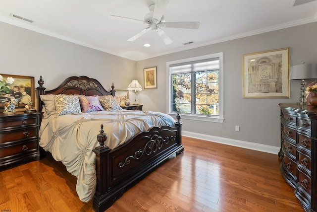 bedroom with wood-type flooring, ornamental molding, and ceiling fan