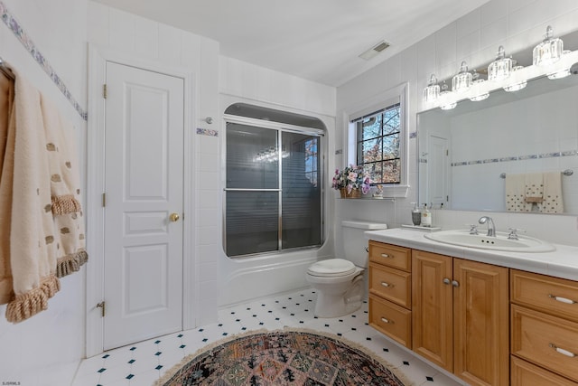 full bathroom with toilet, vanity, shower / bath combination with glass door, and tile walls