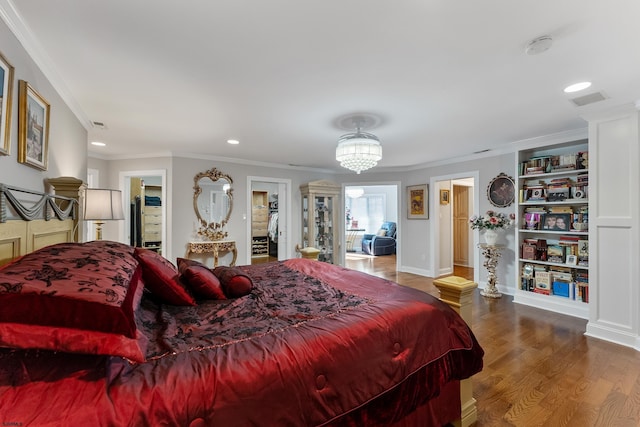 bedroom with connected bathroom, hardwood / wood-style floors, and crown molding