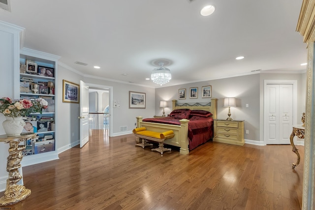 bedroom with an inviting chandelier, ornamental molding, and wood-type flooring