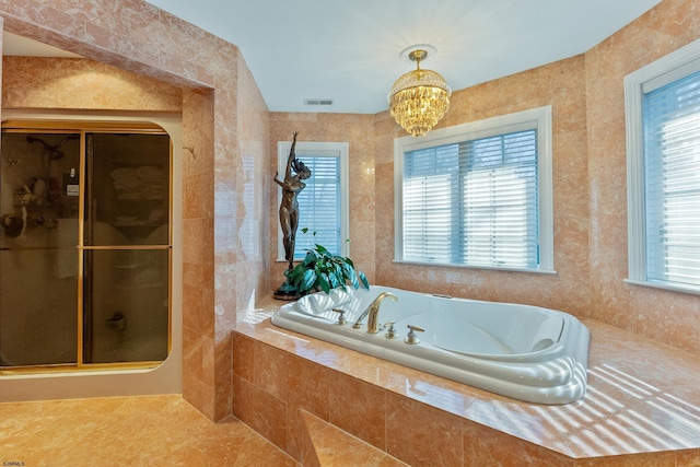 bathroom featuring a healthy amount of sunlight, plus walk in shower, and a chandelier