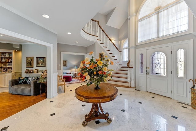 entrance foyer featuring crown molding and a high ceiling