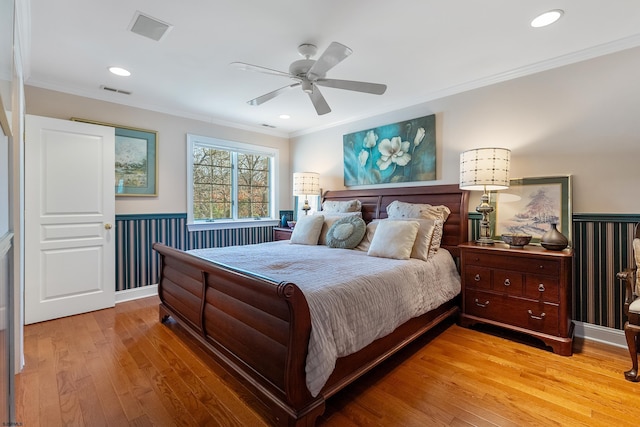 bedroom featuring hardwood / wood-style flooring, ceiling fan, and crown molding