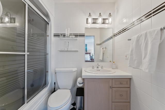 full bathroom with enclosed tub / shower combo, tile walls, vanity, decorative backsplash, and toilet