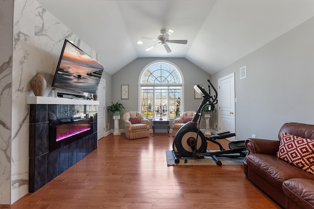 workout room featuring vaulted ceiling, hardwood / wood-style floors, and ceiling fan