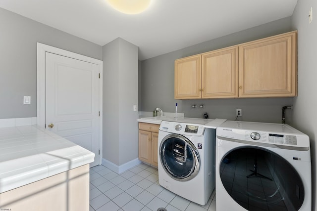 washroom with cabinets, sink, light tile patterned floors, and washing machine and clothes dryer