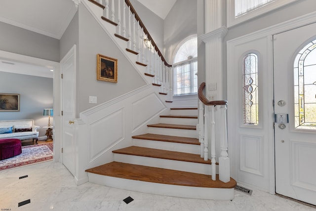 entrance foyer with ornamental molding and plenty of natural light