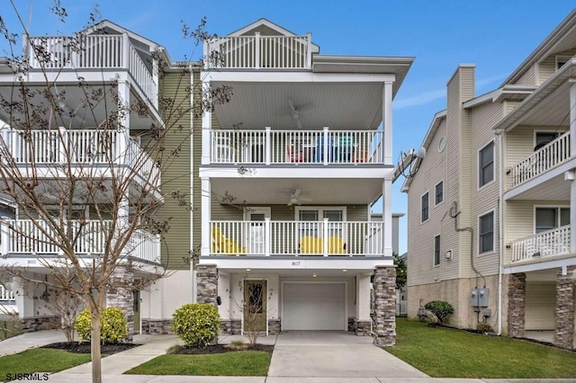 view of front of property with a garage, a balcony, and a front lawn