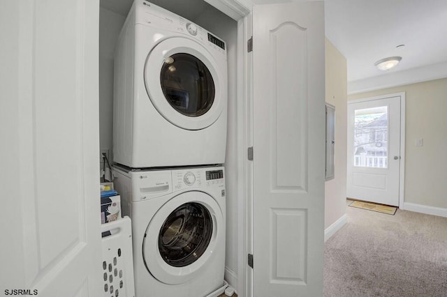 laundry area featuring stacked washing maching and dryer and light colored carpet