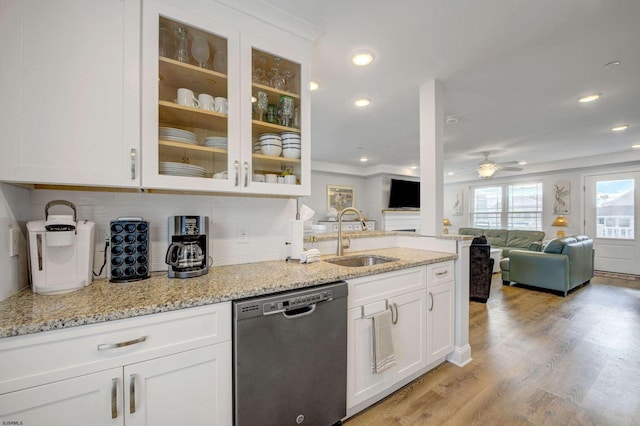 kitchen featuring stainless steel dishwasher, light stone countertops, sink, and white cabinets