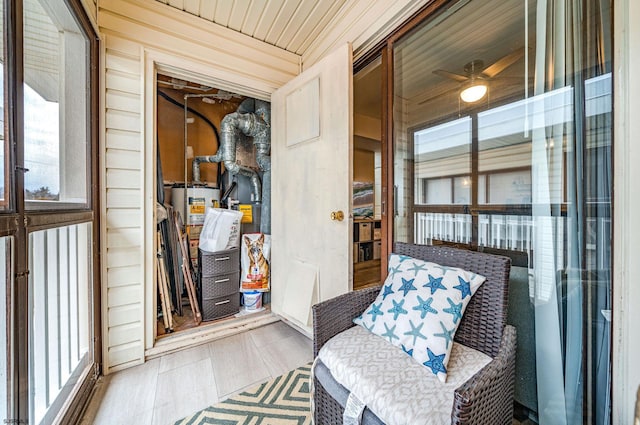 sunroom / solarium featuring gas water heater, wood ceiling, and ceiling fan